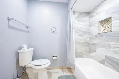 a white bathroom with a toilet and a bath tub at Disney Universal Family Resort # Pool # Gym in Orlando