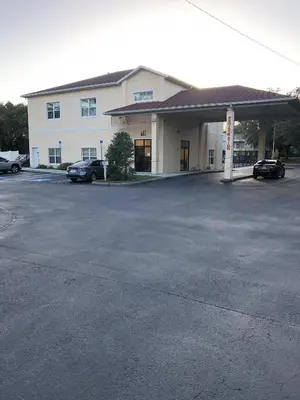 a parking lot in front of a building at Green Palms Extended Stay in Kissimmee