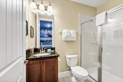 a bathroom with a toilet and a sink and a shower at Home With Movie Theater, Game & Theme Room Near Disney With Resort & Waterpark Access - 7621Wi in Orlando