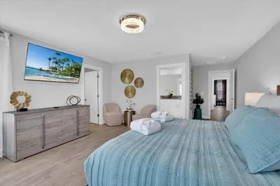a bedroom with a large bed and a tv on the wall at Charming 4 Bdr Villa near Disney in Kissimmee