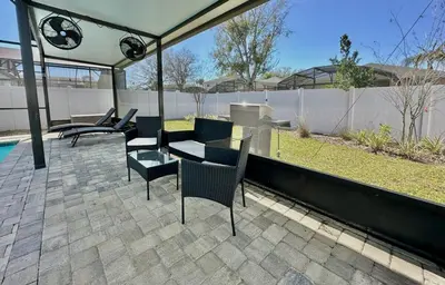 a patio with chairs and a table and a fence at Charming 4 Bdr Villa near Disney in Kissimmee