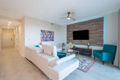 a living room with a white couch and a tv at C4731-203-Storey Lake Resort Near Disney-Universal in Kissimmee