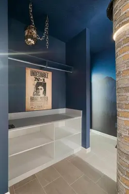 a room with a shelf with a poster and a chandelier at Orlando Paradise 5BR Themed Home in Orlando