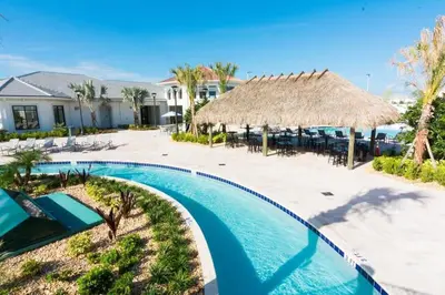 a resort with a swimming pool and a thatch roof at Casa 5Q c/ Piscina Privativa no Storey Lake in Kissimmee