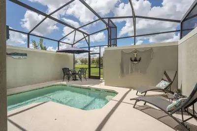 an indoor swimming pool with a glass roof and chairs at Casa 5Q c/ Piscina Privativa no Storey Lake in Kissimmee