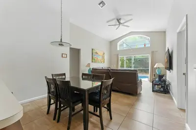 a dining room and living room with a table and chairs at Vila 4Q com Piscina Privativa – Lake Berkley in Kissimmee