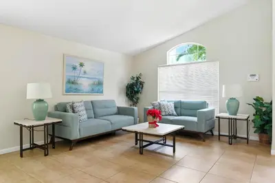 a living room with two blue couches and a table at Vila 4Q com Piscina Privativa – Lake Berkley in Kissimmee