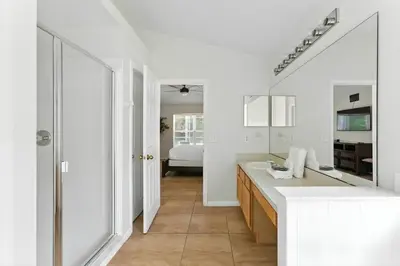 a white bathroom with a sink and a mirror at Vila 4Q com Piscina Privativa – Lake Berkley in Kissimmee