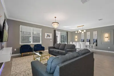 a living room with a couch and a dining room at Casa 9Q em Resort c/ Piscina – 11km da Disney in Kissimmee