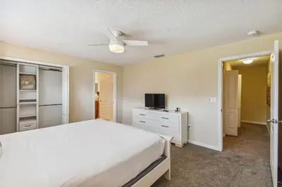 a bedroom with a white bed and a tv at 4Q/ Paradise Palms com Piscina Privativa in Kissimmee