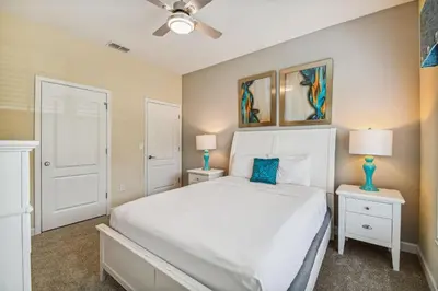 a bedroom with a white bed and two night stands at 4Q/ Paradise Palms com Piscina Privativa in Kissimmee