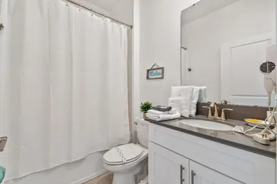 a white bathroom with a sink and a toilet at Storey Lake * Linda Casa 5 quartos com sala de jogos in Kissimmee