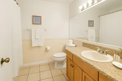 a bathroom with a sink and a toilet and a mirror at Casa 3 Quartos c/ Piscina perto da Disney! in Kissimmee