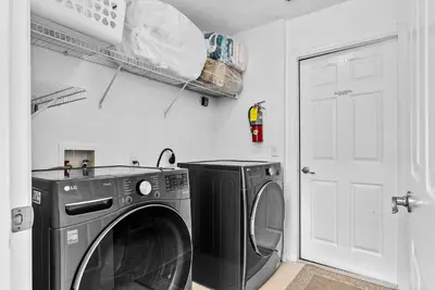 a laundry room with a washing machine and a white door at Comfortable 6-Bedroom Getaway Near Top Attractions in Kissimmee