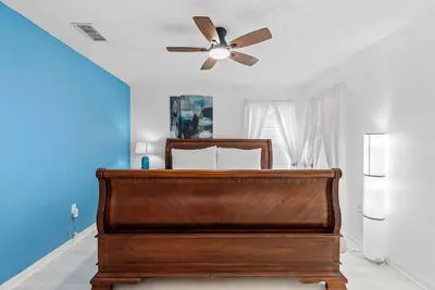 a bedroom with a bed with a ceiling fan at Comfortable 6-Bedroom Getaway Near Top Attractions in Kissimmee