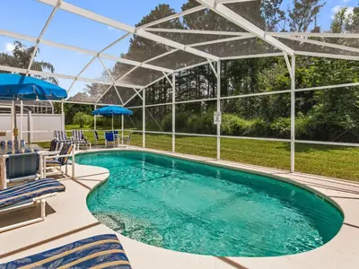 a pool with chairs and umbrellas next to at Holiday Home Ferienvilla mit Garten- Grill und Terrasse by Interhome in Orlando
