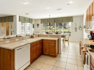 a large kitchen with wooden cabinets and white appliances at Holiday Home Bella Vida Resort Pool und Spa Rückzugsort by Interhome in Kissimmee