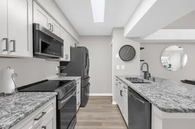 a kitchen with black appliances and marble counter tops at Resort Stay Near Disney Bright Gym Hot Tub in Kissimmee