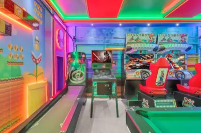 a room with a video game room with arcade equipment at Unforgettable 8-Bedroom Luxury Retreat in Orlando