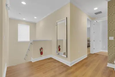 an empty living room with a fire hydrant and a mirror at Unforgettable 8-Bedroom Luxury Retreat in Orlando