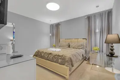 a white bedroom with a large bed and a lamp at Unforgettable 8-Bedroom Luxury Retreat in Orlando