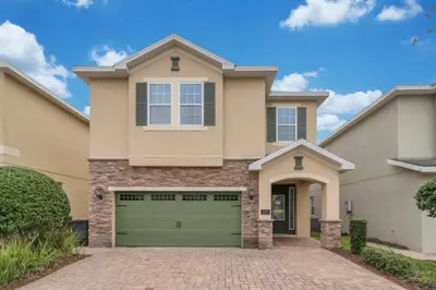 a house with a garage in front of it at Unforgettable 8-Bedroom Luxury Retreat in Orlando