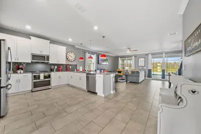 a large kitchen with white cabinets and a living room at 4177 Paragraph Drive in Kissimmee