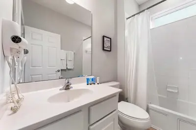 a bathroom with a sink and a toilet and a mirror at 4449 Shiva Loop in Kissimmee