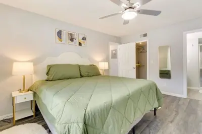 a bedroom with a green bed and a ceiling fan at Villa at Laguna Bay in Kissimmee