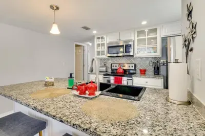 a kitchen with a granite counter top and a refrigerator at Villa at Laguna Bay in Kissimmee