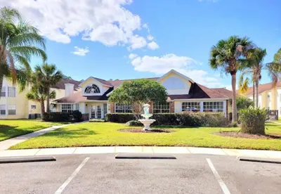 a house with a fountain in the middle of a driveway at Villa at Laguna Bay in Kissimmee
