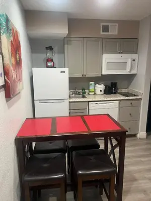 a kitchen with a table with chairs and a white refrigerator at Condo Universal Disney Epic Free Parking in Orlando