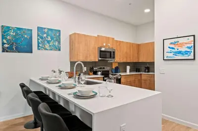 a kitchen with a large white table with chairs at Riviere Apartments King Bed Suite & Pool & Gym & Pet Friendly & Near Epic Universe in Orlando