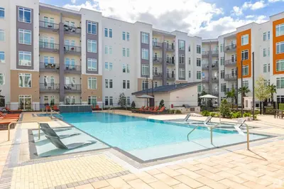 an image of a swimming pool at a apartment complex at Riviere Apartments King Bed Suite & Pool & Gym & Pet Friendly & Near Epic Universe in Orlando