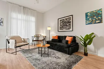 a living room with a black couch and a table at Riviere Apartments King Bed Suite & Pool & Gym & Pet Friendly & Near Epic Universe in Orlando