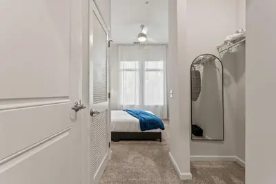 a hallway with a bed and a mirror in a room at Riviere Apartments King Bed Suite & Pool & Gym & Pet Friendly & Near Epic Universe in Orlando