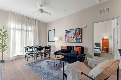 a living room with a couch and a table at Riviere 2BR Apartment Pet Friendly Oasis Sleeps 6 Close to Epic Universe Pool & Gym in Orlando
