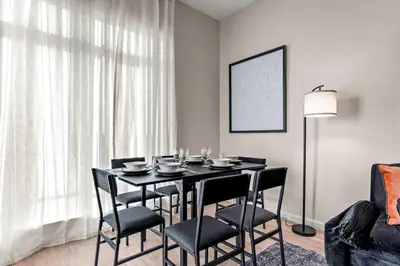 a dining room with a black table and chairs at Riviere 2BR Apartment Pet Friendly Oasis Sleeps 6 Close to Epic Universe Pool & Gym in Orlando