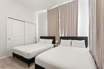 two beds in a room with white walls and white ceilings at Riviere 3BR Apartment Stylish King Family Pets Friendly Pool & Gym Near Epic Universe in Orlando
