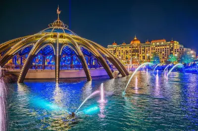 a bridge with water fountains in front of a building at Riviere 3BR Apartment Stylish King Family Pets Friendly Pool & Gym Near Epic Universe in Orlando