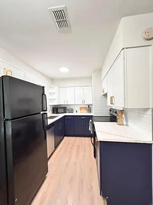 a kitchen with blue cabinets and a black refrigerator at Cozy Modern 3BR Escape - Sanford in Sanford
