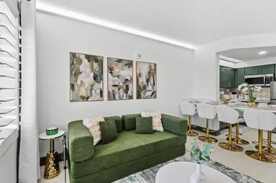 a living room with a green couch and a table at Cozy 1BR near Universal International Drive in Orlando