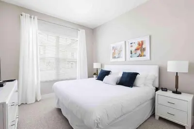 a white bedroom with a large bed and a window at Townhome 4Q em Summerville Resort – Orlando in Orlando