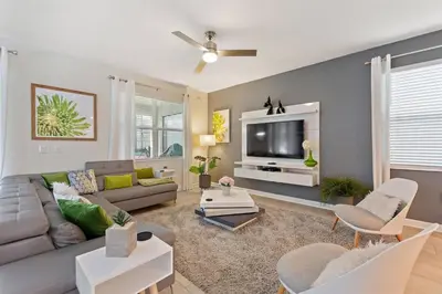 a living room with a couch and a tv at Bookmark Villa 8Q no Storey Lake c/ Piscina in Kissimmee
