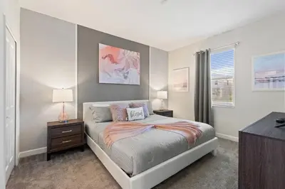 a bedroom with a bed and two lamps and a window at Bookmark Villa 8Q no Storey Lake c/ Piscina in Kissimmee