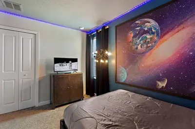 a bedroom with a large painting on the wall at Bookmark Villa 8Q no Storey Lake c/ Piscina in Kissimmee