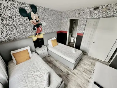a room with a mickey mouse bedroom with two beds at Entire condo near Universal Studios in Orlando - Free Resort Access in Orlando