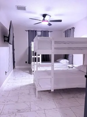 a bedroom with two bunk beds and a ceiling fan at Game Day Getaway-Downtown Orlando in Orlando