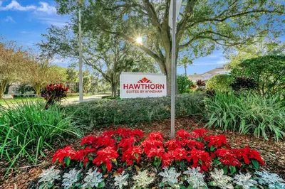a sign for a hampton inn with red flowers at FREE Shuttle & 50 Dollars Disney Gift Card Disney Resort Condo in Orlando