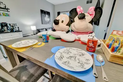 two stuffed animals sitting on a table with plates at FREE Shuttle & 50 Dollars Disney Gift Card Disney Resort Condo in Orlando